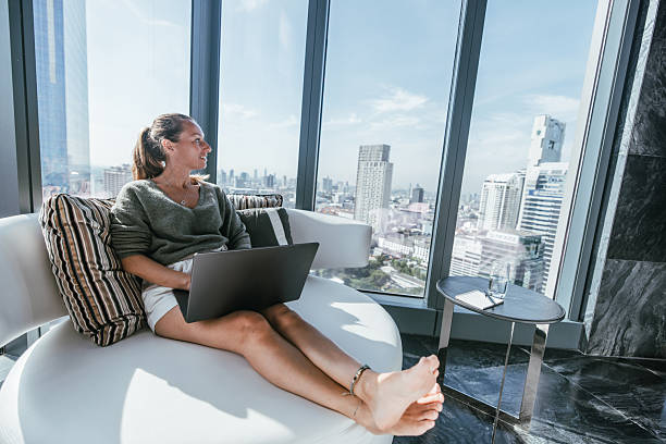 istock Modern woman investing on her computer, city view 2207343251