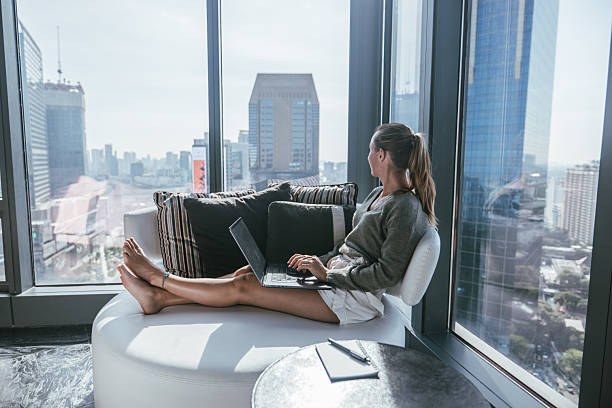 istock A woman working on her laptop, city view 2207343417
