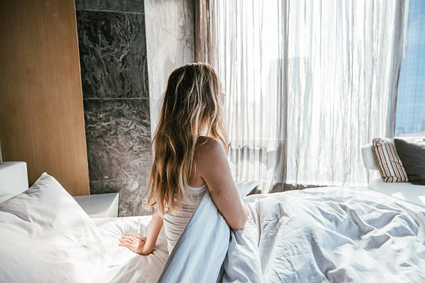 istock Woman enjoying morning sunlight from bed. 2207343518