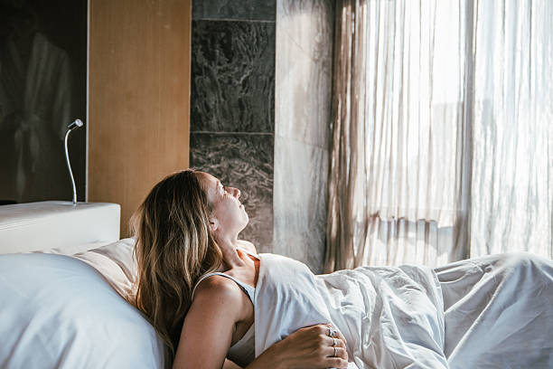 istock Woman enjoying morning sunlight from bed. 2207343616