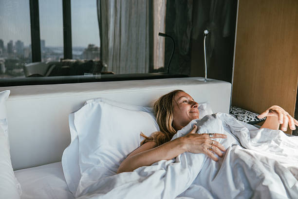 istock Woman relaxing in a cozy, sunlit bedroom. 2207343802