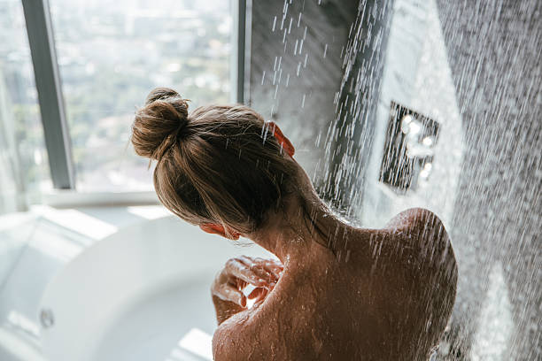 istock Woman enjoying a refreshing shower with a city view. 2207343891