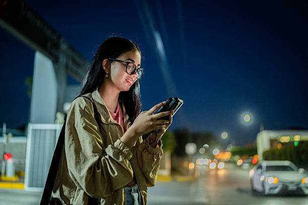istock Young woman using mobile phone on city street 2207347817