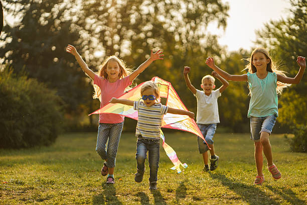 istock Children having fun while playing whit kite in park 2207352495