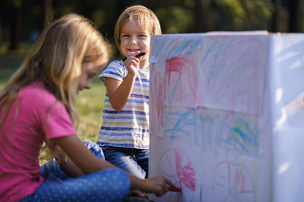 Young child focused on a creative painting activity, using vibrant colors and an artistic setting