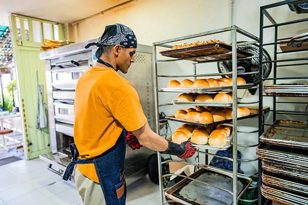 Mid adult man preparing baked item at bakery kitchen