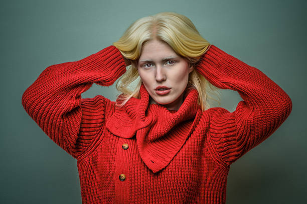 Model in bold red sweater poses dramatically against a green backdrop