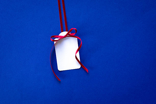 Gift Tag with Red Ribbon on a Blue Background