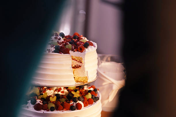 The bride and groom cut into an elegant, luxurious wedding cake, a timeless tradition symbolizing their union. This beautifully decorated dessert is the highlight of the wedding reception, adding sweetness to the celebration.