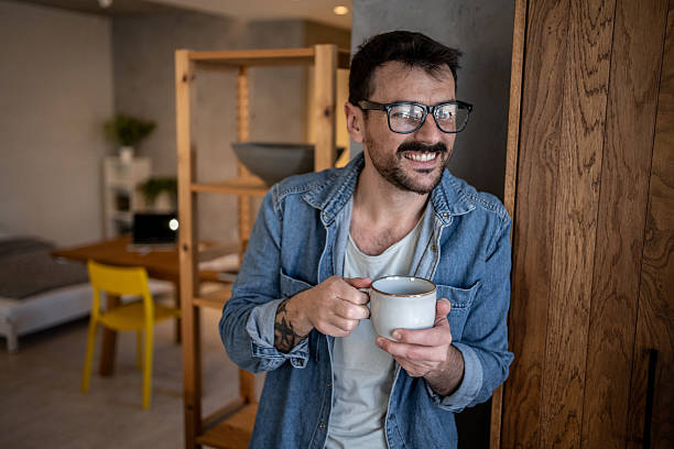 istock Smiling man enjoying a cup of coffee at home 2207362502