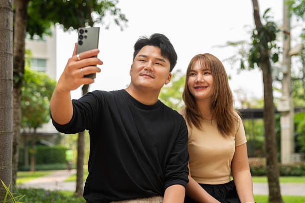 istock Young Asian couple outdoors in park 2207362609