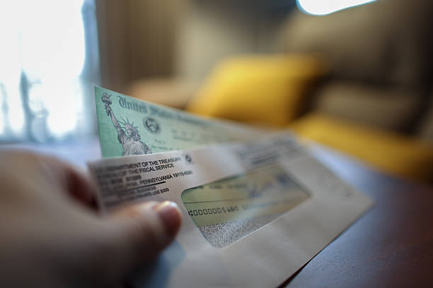 istock Man holding a tax refund check 2207368311