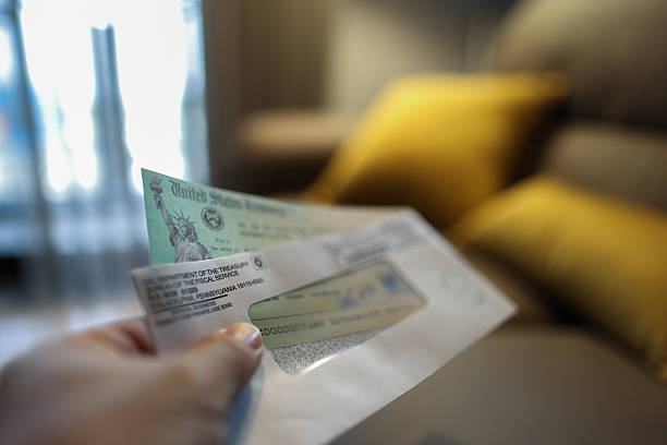 istock Man holding a tax refund check 2207368318