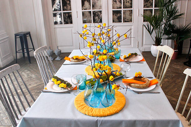 istock Easter table setting in yellow and blue colors, with yellow flowers, chickens on branches and blue vases 2207368321