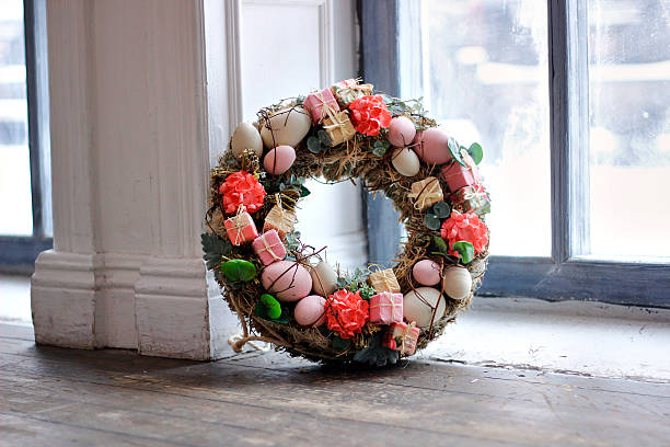 istock A large pink Easter wreath with eggs and flowers stands against a white wall 2207368603