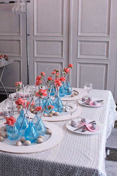 istock modern Easter table setting with blue vases, pink flowers and wooden eggs in a white interior 2207368791
