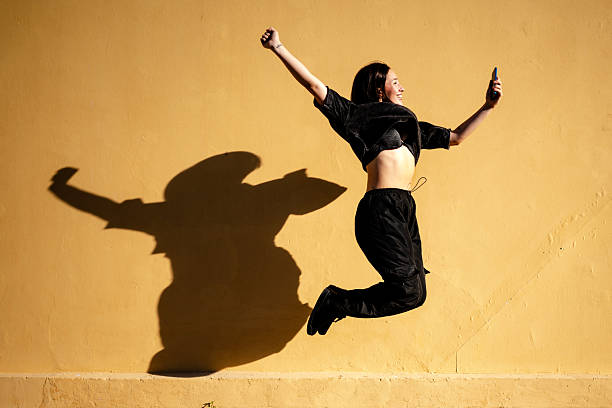 Young millennial woman using smartphone and posing for camera