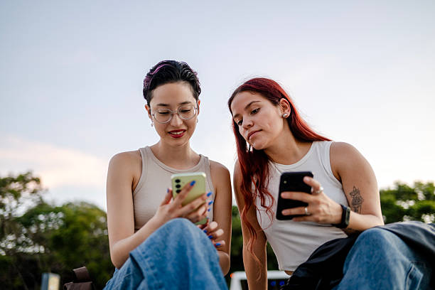 Two young Millennial women using smartphones