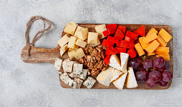 istock Assorted cheese on a wooden board, with grapes and walnuts, appetizer, no people. 2207371400
