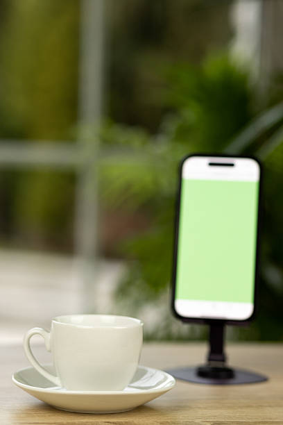 A cup of coffee and a smartphone. Smartphone on a stand. Chroma key. Coffee break. High quality photo