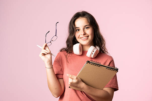 istock Young student smiling and holding a notebook and pen 2207377939