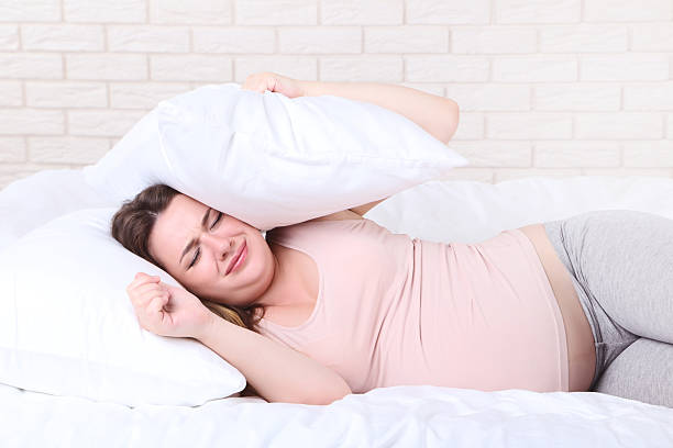 istock Young pregnant woman sleeping in bed 2207378824