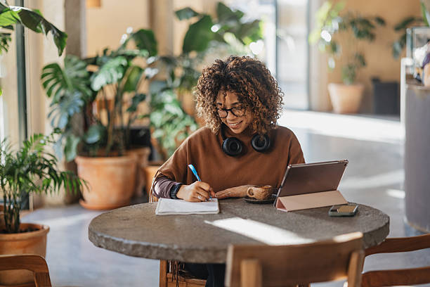istock Woman Writing Notes and Enjoying Coffee 2207379140