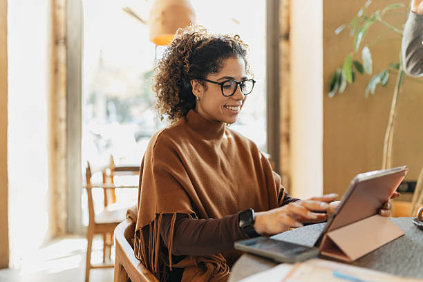 istock Smiling Woman Engaging with Tablet at Cafe 2207379216