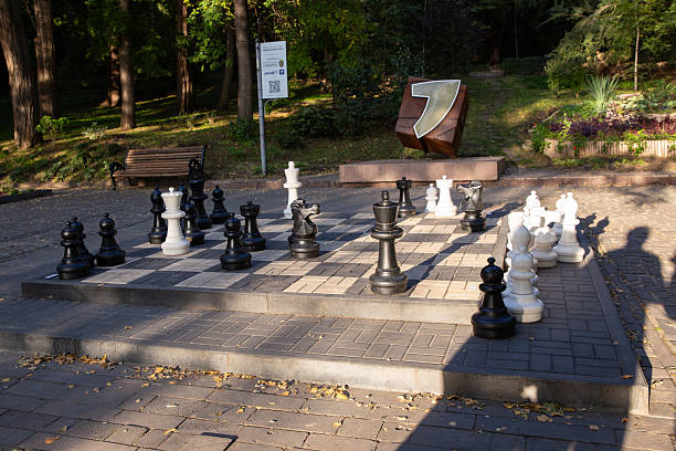 istock Large chessboard with chess pieces, street chess game location, chess game 2207379859