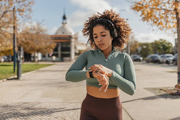 istock Concentration while checking fitness tracker outdoors 2207380760