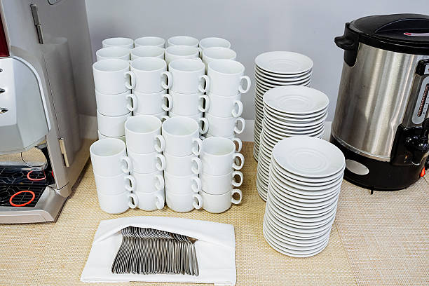 A beautifully arranged table features an organized stack of charming coffee cups and plates, creating an inviting ambiance for enjoying a warm beverage or meal with friends