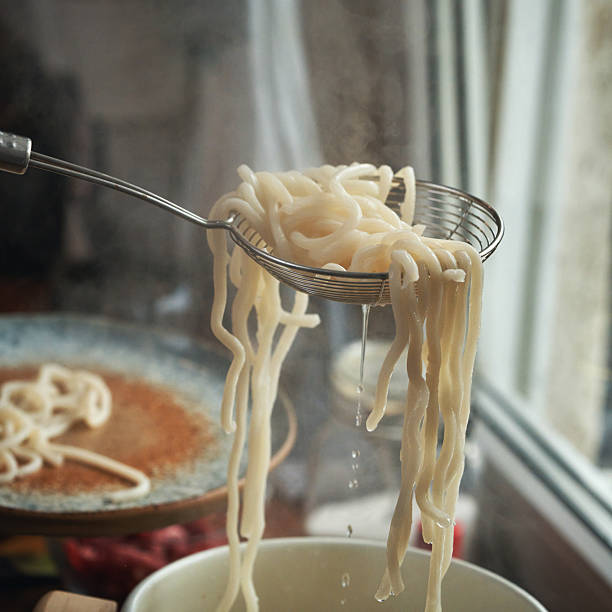 Preparing Udon Noodles in a Cooking Pot in Domestic Kitchen