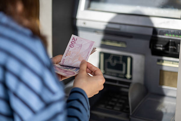 istock woman withdrawing money from ATM 2207391009
