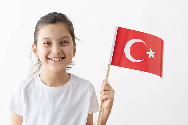 istock Smiling Girl Holding Turkish Flag on White Background 2207392620