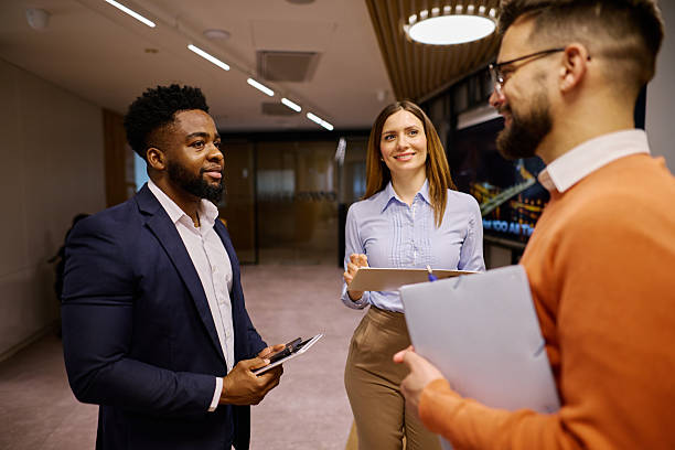 istock Business team discussing work in modern office hallway 2207394226