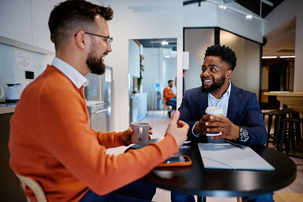 istock Two smiling businessmen enjoying a coffee break in a modern office 2207394256