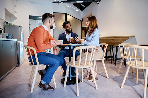 istock Businesspeople having a coffee break meeting in modern office cafeteria 2207394264