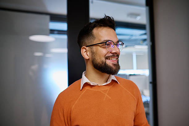 istock Young businessman smiling and looking away in modern office 2207394401