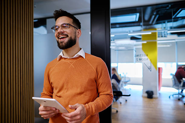 istock Smiling businessman holding digital tablet in modern office 2207394428