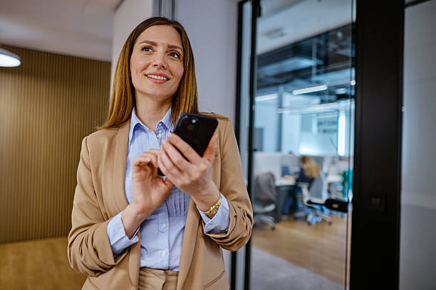 istock Businesswoman using smartphone in modern office and looking away 2207394631