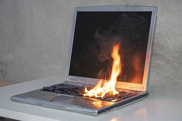istock Danger of overheating: the laptop burns, spreading smoke and fire. 2207395590