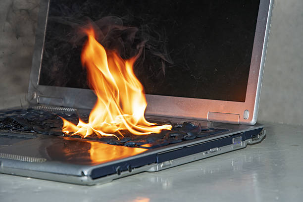 istock Laptop fire in the workplace caused by overheating or short circuit. 2207395905