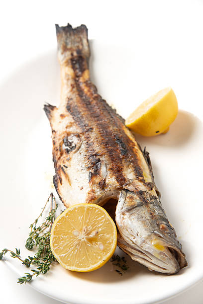 Baked (or fried grilled) sea bass fish with spices, salt, lemon and thyme