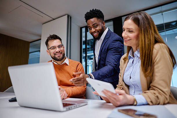 istock Business team collaborating on project, analyzing data on laptop and tablet in modern office 2207399850