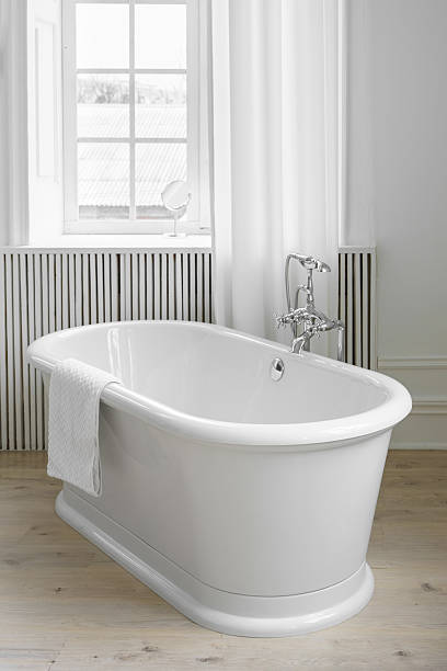 istock Modern elegant minimalist bathroom interior with curtains and window and freestanding bathtub 2207403017