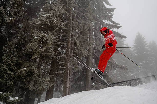 istock Skier performing a jump on snowy mountain terrain amidst a winter forest 2207409357