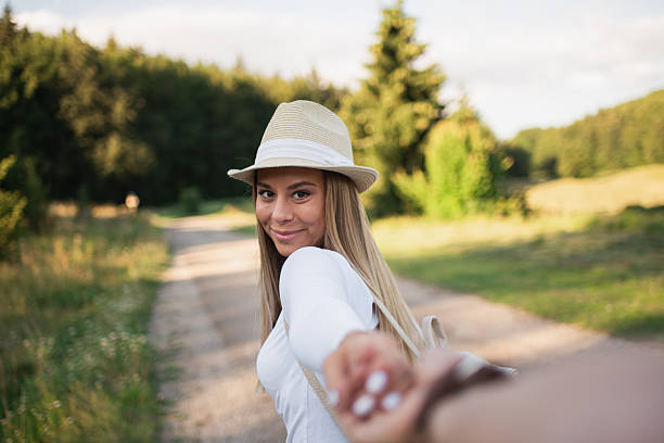 istock Happy woman leading hand on countryside path 2207412667