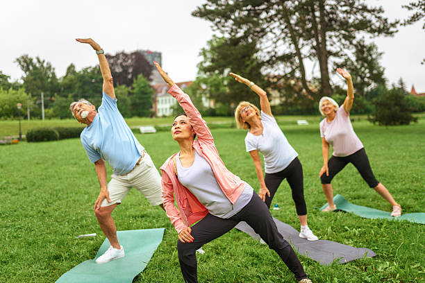 istock Senior Group Outdoor Yoga with Diverse Instructor 2207413034
