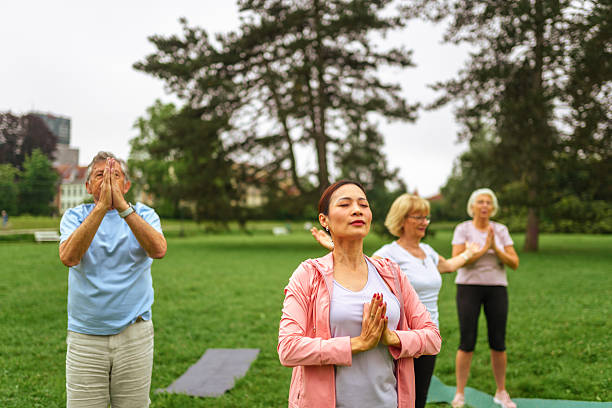 istock Senior Group Outdoor Yoga Session with Instructor 2207413041