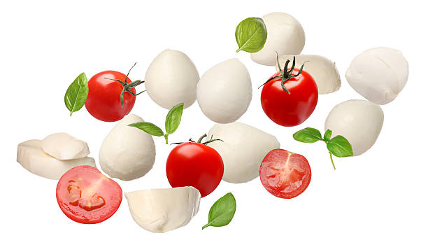 istock Ingredients for Caprese salad. Mozzarella balls, basil and tomatoes falling on white background 2207413922